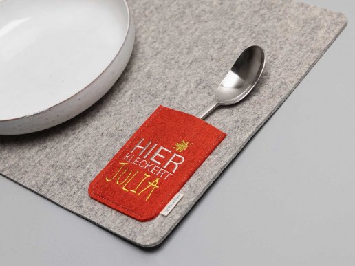Tischset-aus-Natur-Filz-mit-Tasche-fuer-Besteck-bestickt-Text-hier-kleckert-Wunschname